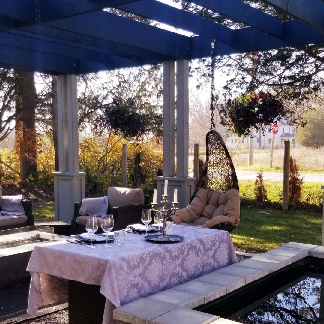 Table with wine glasses, candles, beside koi pond