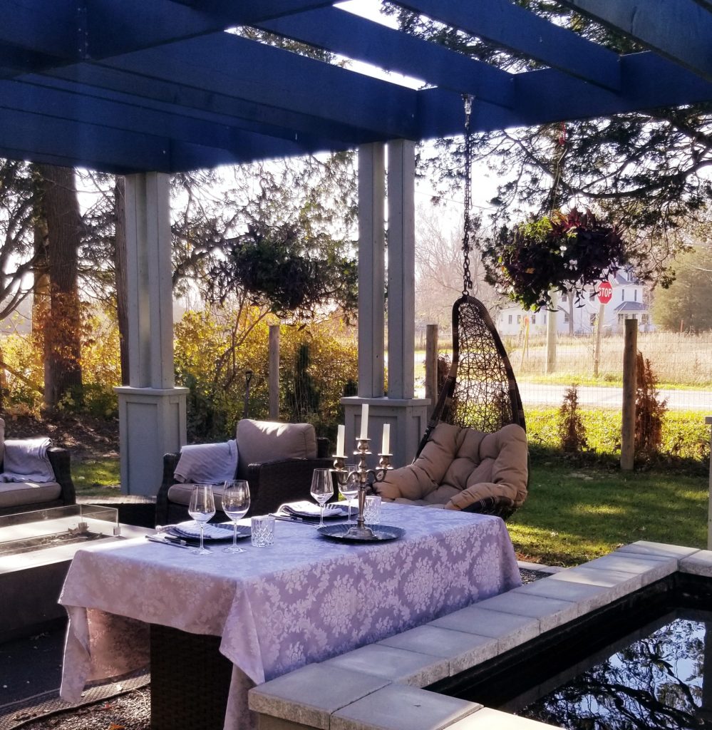 Table with wine glasses, candles, beside koi pond