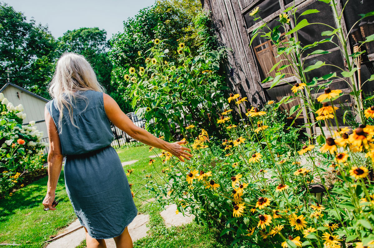 Woman walking beside flower garden
